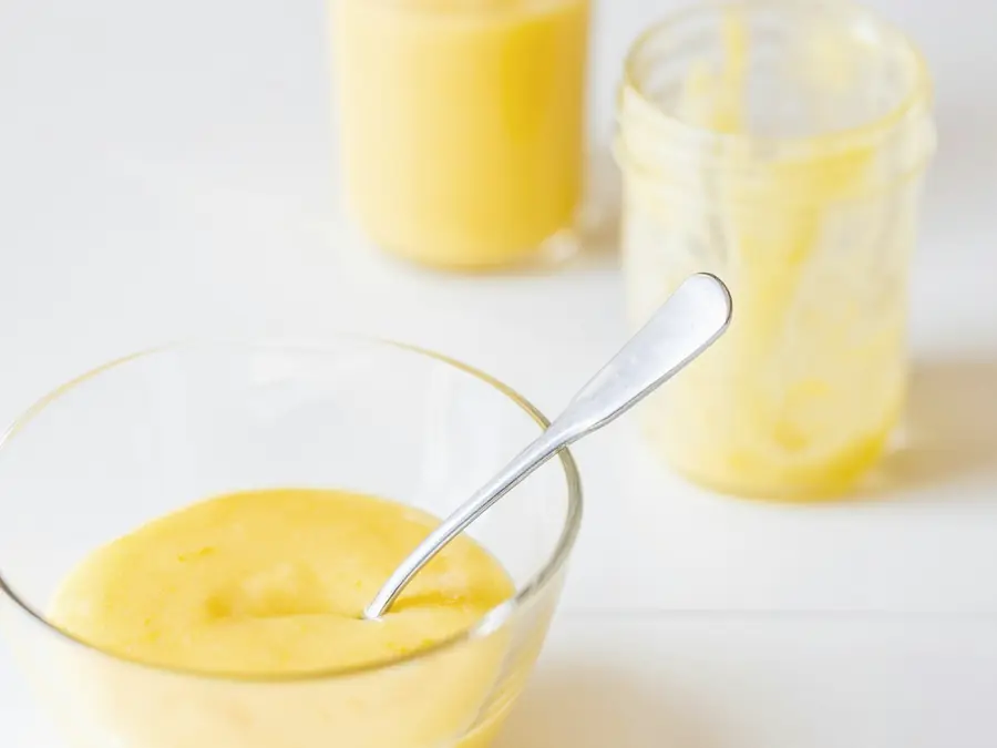 Glossy custard being stirred in a glass bowl