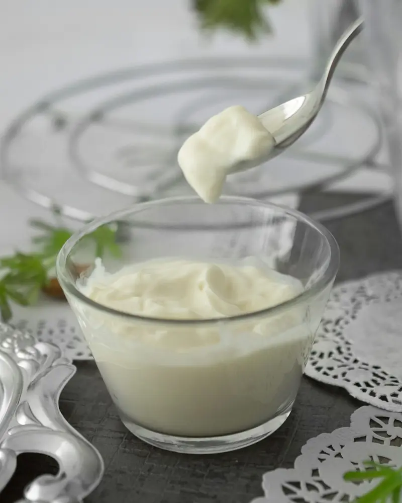 A spoonful of thick, set yoghurt lifted from a glass