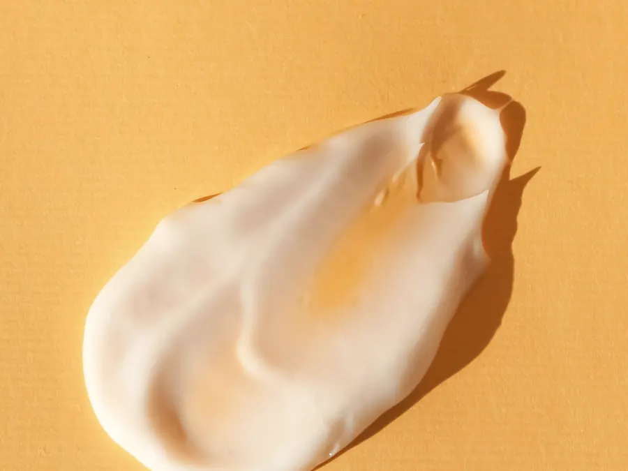 A thick swirl of mayonnaise on a yellow surface